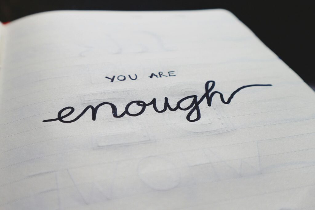 pexels photo 669988 669988 A close-up of a notebook page with motivational handwritten text: "You are enough."